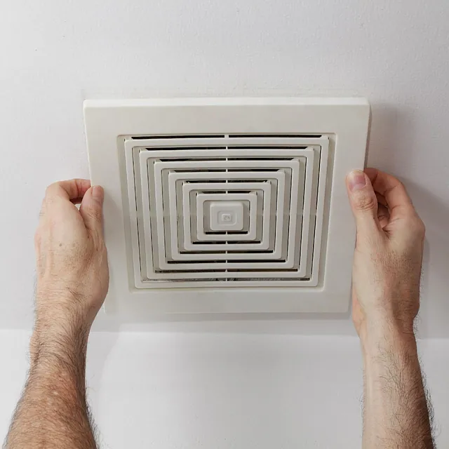A person attempting to remove an air duct cover using their hands